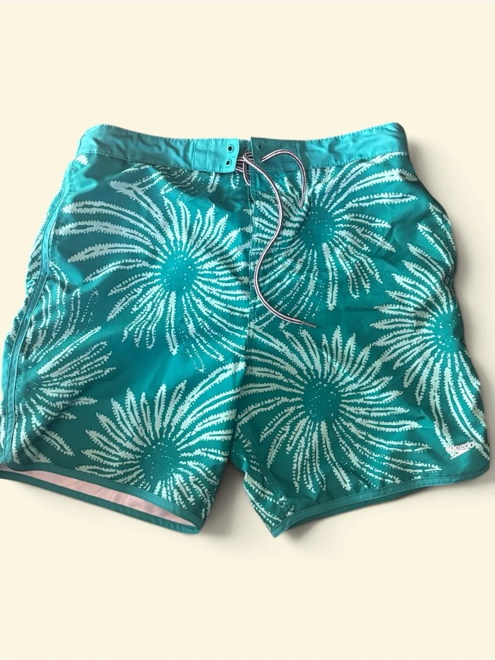 Speedo men's swim shorts with white floral pattern on teal background, size XL